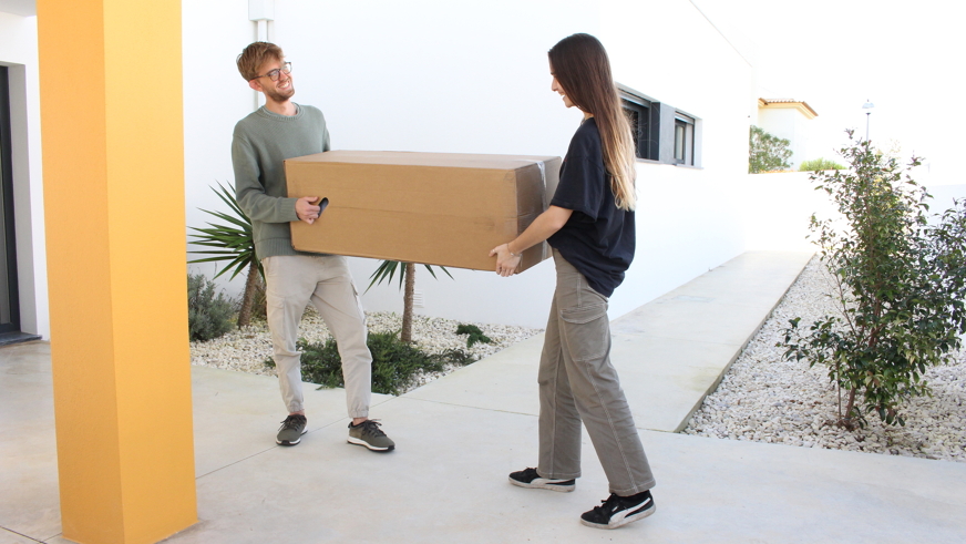 two people carrying a mattress